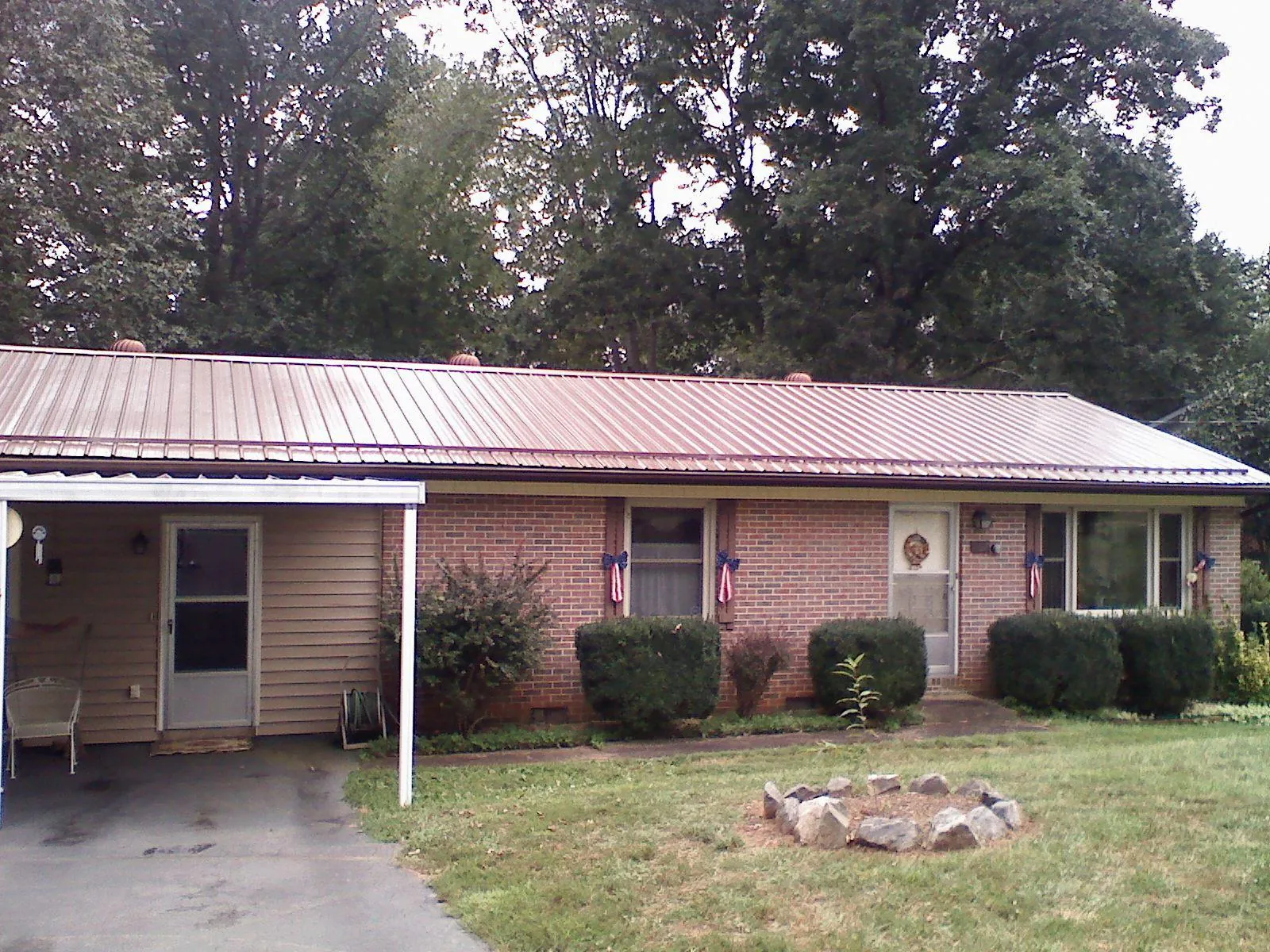 Bronze metal roof and carport on a brick ranch home — Roof Repair work by our crew in Basco